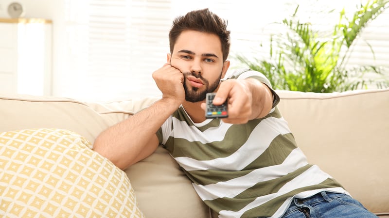 lazy man watching TV - photo by Chernetskaya, Dreamstime. A woman is mad at her deadbeat son-in-law, who lets his wife do all the work, from childcare to a fulltime job. See what Ask Amy advises.