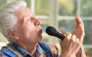 man singing karaoke Ruslan Huzau Dreamstime, for article on misheard lyrics - misheard song lyrics. Greg Schwem likes to sing along to songs, but he admits to botching the lyrics, turning a classic rock song into a puzzling reprised version. Image
