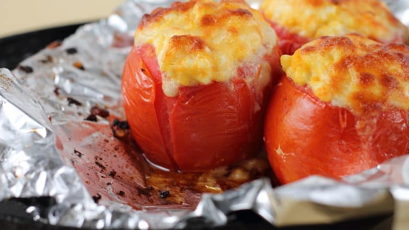 stuffed tomatoes - photo by Tetiana Istomina, Dreamstime. Ripe and juicy grilled stuffed tomatoes, a summertime rewards, are stuffed with cheese, rice, and pesto, topped with toasted pine nuts. Image