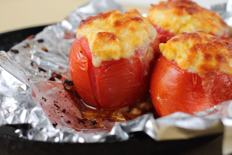 stuffed tomatoes - photo by Tetiana Istomina, Dreamstime. Ripe and juicy grilled stuffed tomatoes, a summertime rewards, are stuffed with cheese, rice, and pesto, topped with toasted pine nuts.