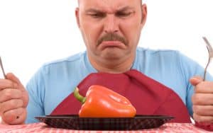 unhappy dieter with a pepper on his plate - photo by Simone Van Den Berg, Dreamstime. Is it okay to cheat on a diet? Or should I follow my weight-loss diet strictly and carefully and always avoid “cheat meals”? Image