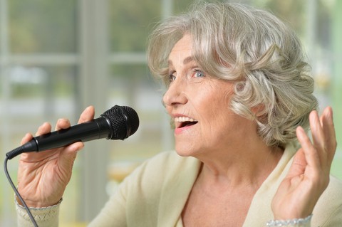 woman with microphone - photo by Ruslan Huzau, Dreamstime, for article on misheard lyrics. Greg Schwem likes to sing along to songs, but he admits to botching the lyrics, turning a classic rock song into a puzzling reprised version.