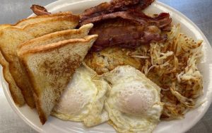 Charlie's Way Platter, a breakfast platter, pictured here with two fried eggs, hash browns, bacon, and toast. Richmond food and travel writer Steve Cook takes us to Charlie’s Way Kitchen, for food done right at a reasonable price – breakfast and lunch, in a pandemic-pivot food truck and “car wash” setting, from an experienced food-service family. Image