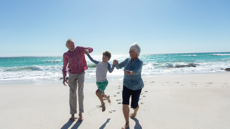 grandparents with boy on beach. Photo by Wavebreakmedia Ltd, Dreamstime. for article on revisiting vacation spots of the past