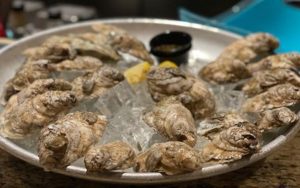 raw oysters on a platter. Richmond food and travel writer Steve Cook gives three reasons why Happy Hour at Latitude Seafood Co. will make you sing. Image