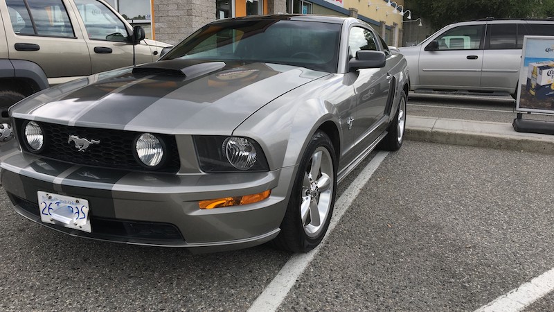 A gray 45th-anniversary Mustang with a glass roof, five-speed standard transmission. Wesley Shennan appreciates his Mustang as well as efforts to curb global warming. He wonders, what does the future of the car look like? Image