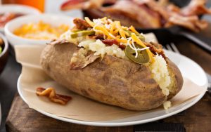 Baked potato with toppings. Image by Elena Veselova, Dreamstime. A baked potato bar with creative toppings like these are perfect for football watch parties, game night, or simply an easy dinner at home. Image