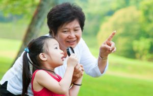 grandmother and granddaughter together looking closely outside something outside. Image by Szefei, Dreamstime. Mom plays favorites, so Grandmom plays favorites with the disfavored granddaughter. Do two rights make a wrong? See what “Ask Amy” says. Image