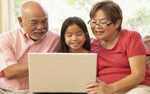 grandparents with granddaughter on a laptop computer, possibly doing a puzzle. Image by Monkey Business Images, Dreamstime. Image