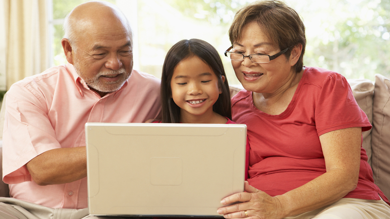 grandparents with granddaughter on a laptop computer, possibly doing a puzzle. Image by Monkey Business Images, Dreamstime Image