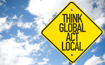 Think Global Act Local sign with sky background
