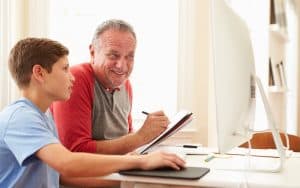 Granddad and grandson working on a computer, perhaps for a Jumble Puzzles Image