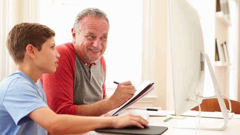 Granddad and grandson working on a computer, perhaps for a Jumble Puzzles Image