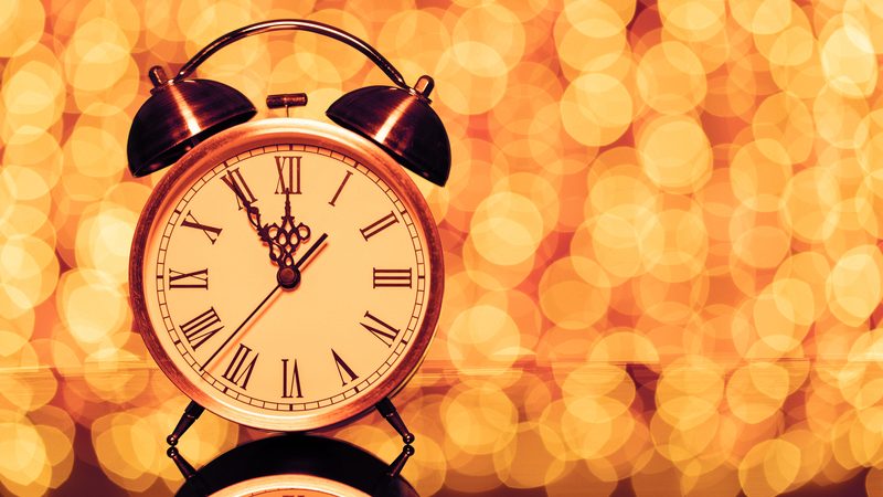 Old alarm clock nearing 12 with lights blurred in the background, marking the countdown to New Year's Eve. More of What’s Booming in Richmond, Virginia, from December 29, 2022 to January 3, 2023: New Year’s Eve, music, event news, and more. Image
