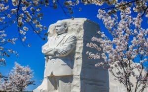 Martin Luther King Jr monument in Washington, D.C., surrounded by cherry blossoms. Image by Steven Roncin. Celebrate diversity & equality by honoring MLK Day and peace, + a Jewish Food Festival, Big Band music, and not-peaceful “Friday the 13th.” Image