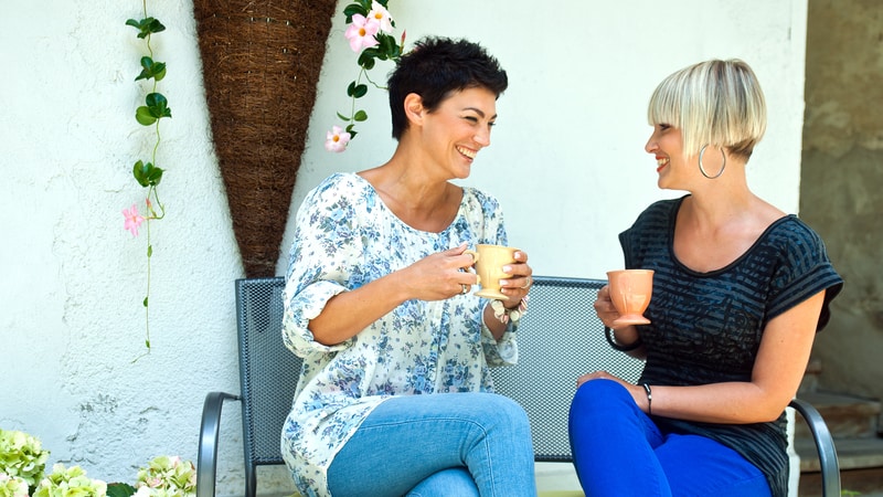 two women chatting, outside, seated, with coffee. Image by Dean Bertoncelj. These 5 gratifying resolutions are easy and enjoyable, yet they can improve us from the inside out so we can achieve the external goals. Image