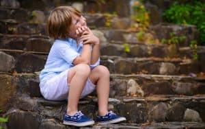 young boy sitting on stone steps. by Tatiana Bobkova. As Boomer reader R.G. Begora recalls his childhood, he recalls several tales that make him seem like a bad boy … or a dumb kid. Perhaps you can relate! Image