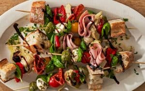 Creamy marinated mozzarella, savory meats, marinated vegetables, plump ripe tomatoes, and fresh herbs come together for the perfect appetizer. Antipasto bites take everything you’d see on a traditional antipasto platter and present a little bite of each element on a personal skewer. Image