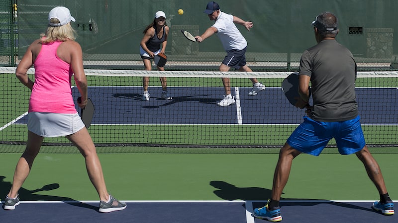 Four people playing pickleball. By Robert Hills. Our senior sport has been commandeered by a younger crowd. Humorist Greg Schwem shares how he feels about the pickleball court takeover.