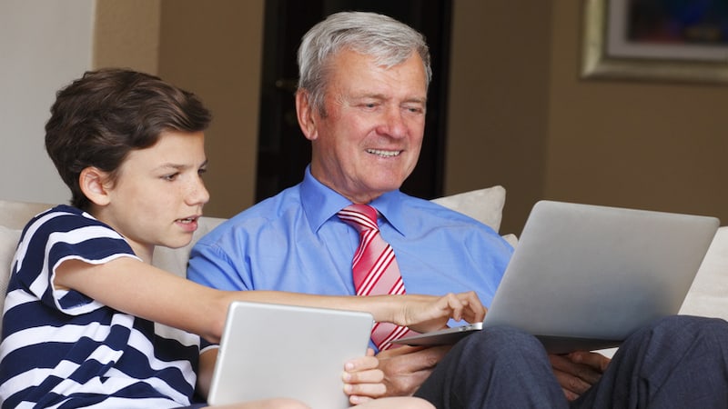 grandson and grandfather on tablet and laptop, possibly doing a puzzle like Jumble. By Sepy67