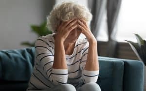 A worried woman with her head in her hands. The woman feels she's moved on after ending a long, terrible marriage, but now that she’s in love again, she fears dating after divorce. Image