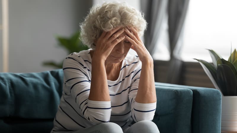 A worried woman with her head in her hands. The woman feels she's moved on after ending a long, terrible marriage, but now that she’s in love again, she fears dating after divorce.