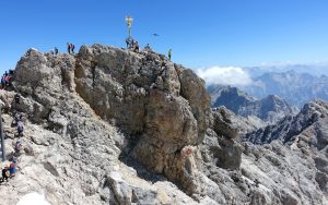 A golden cross marks the top of the 9,700-foot Zugspitze, the highest point in Germany. The mountain straddles the border between Germany and Austria, and lifts from both countries whisk visitors to the top. Travel writer Rick Steves transports us to the Zugspitze in Germany – it's worth a visit! Image