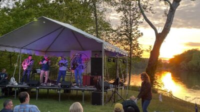 Bluegrass Jam festival by the James River with a sunset in the background