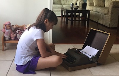 Sofia, a young girl, working on an old manual typewriter