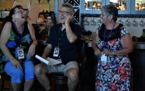 Three 60-something people laughing at their high school reunion. Does a high school reunion lose its appeal 50 years after graduation? Ed Grifone thought so, but he pitched in to help organize one anyway. Image