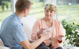 woman taking medication from nurse, Katarzyna Bialasiewicz. A retired nurse shares how being called “sweetie” insults her and feels ageist, paternalistic, and misogynistic. See what “Ask Amy” thinks. Image