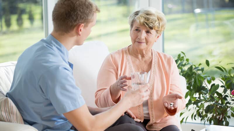woman taking medication from nurse, Katarzyna Bialasiewicz. A retired nurse shares how being called “sweetie” insults her and feels ageist, paternalistic, and misogynistic. See what “Ask Amy” thinks. Image