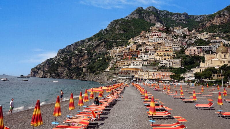 Beyond the colorful hillside buildings, rich blue waters, and relaxing beach, Positano on the Amalfi Coast of Italy holds a wealth of history. Credit Rick Steves. Image