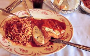 Maggiano's family style dining - plate of spaghetti with meat sauce, and cutlets with parmesan Image