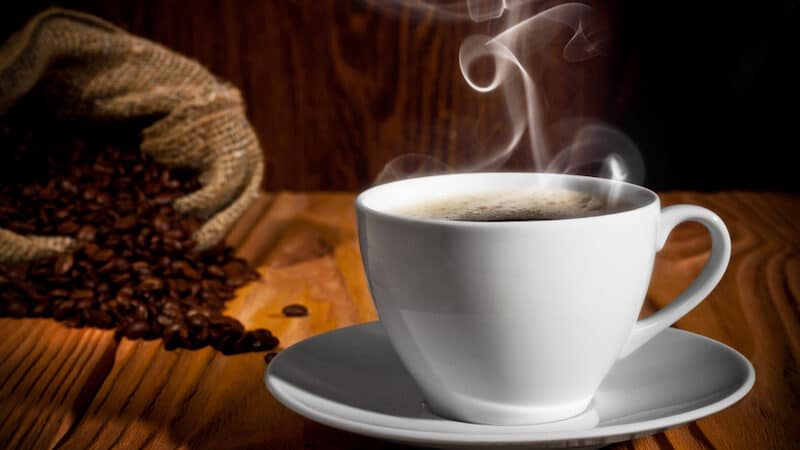 coffee beans spilling from a burlap bag and a steaming cup of coffee. From Bortn66. Colombia is a popular coffee-producing country. This is why Colombian coffee from Mecatos Bakery & Café 32822 is the best quality coffee. Image