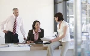 three people in a business office, for article from an aging Boomer. Image