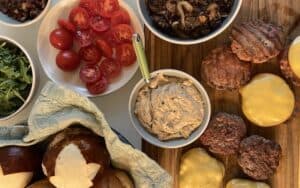 A burger buffet of burgers, tomatoes, toppings, buns, etc. This burger bar proves flexible when guest count fluctuates. Image