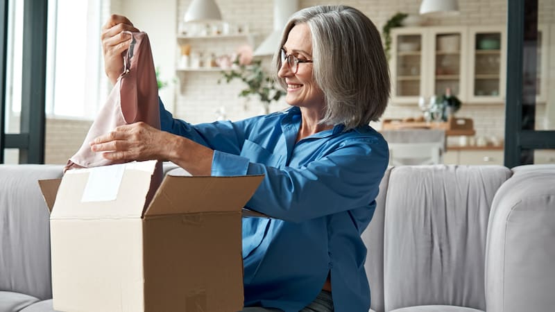 woman smiling as she pulls clothing out of a box. From Dark1elf. Memories encompass events, sights and smells. Julia Nunnally Duncan recalls her mother’s sense of fashion, both her clothing and fragrances.