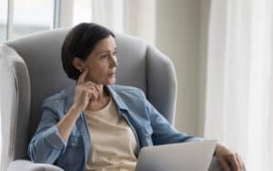 A middle-aged woman looking pensively to the side. Image by Fizkes. Signs of autism in women are different. A woman wants to share this with her sister and mother, who may be autistic. 