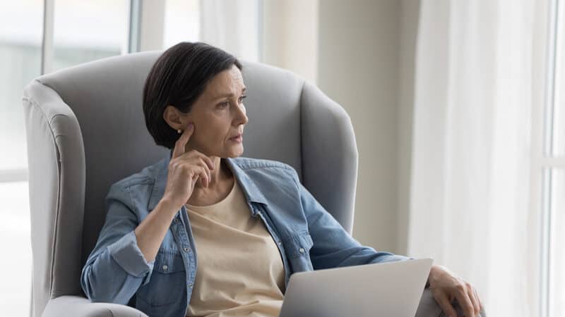 A middle-aged woman looking pensively to the side. Image by Fizkes. Signs of autism in women are different. A woman wants to share this with her sister and mother, who may be autistic.