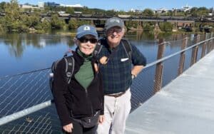 Stuart and Pamela Davis, natives of New York and Maine, and now residents of Arlington, travel to the shores of the James River in Richmond every year for the Richmond Folk Festival: “How wonderful to have something like this in the heart of the city!” They are photographed here on the T-Pott Bridge. Image