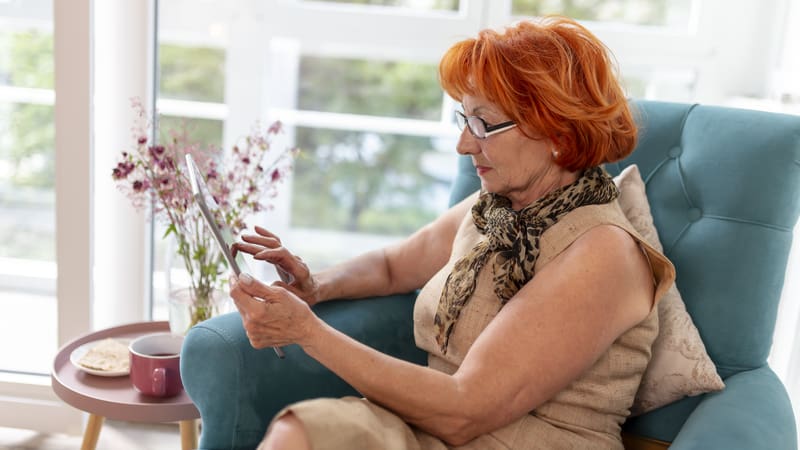 woman looking at a tablet, perhaps playing a puzzle. For this week's Boggle: go fish!