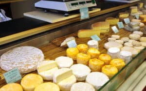 French cheeses in a store display case. Even seasoned travel writer Rick Steves used to be content with American cheese and deride certain “high-falutin’” Old World airs, but since connecting with people in Europe, he has changed his attitude. Image