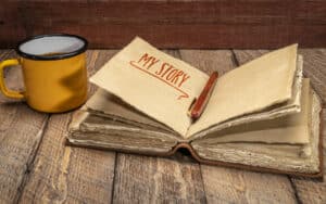 A mug and My Story journal on a wooden table, from Marek Jliasz. Author Rod Martinez writes about the book that you have in you and why you should write your personal memoir. Image