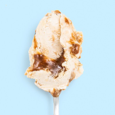 A spoon with a generous dollop of Jeni's Frosted Brown Sugar Cinnamon Ice Cream, launching June 22, 2023.