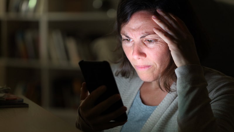 agitated woman looking at cell phone at home in the evening, from Info723783. She’s dating at 45 and Facebook makes her feel like a kid, and not in a good way! See what Ask Amy says about social media and adult dating.