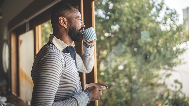 Many looking out of his window and sipping tea. How you begin each day can set the tone for the remainder of your waking hours. Try these 6 tips to start your day strong. Courtesy Getty Images and Buddha Teas
