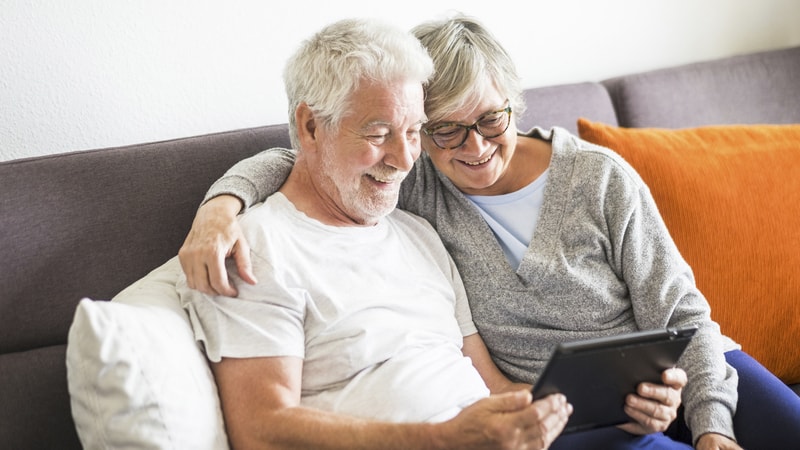 senior couple looking at a computer tablet together. For Boggle puzzle