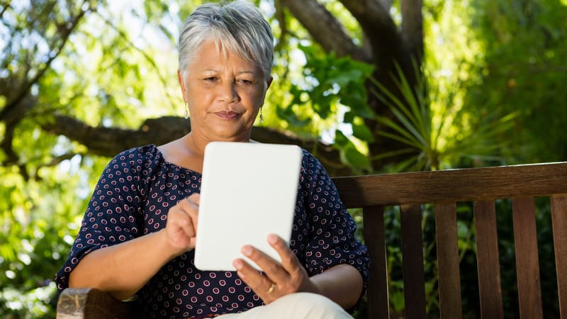 woman outside with tablet, by Wavebreakmedia, perhaps even play Boggle's state capitals puzzle word search