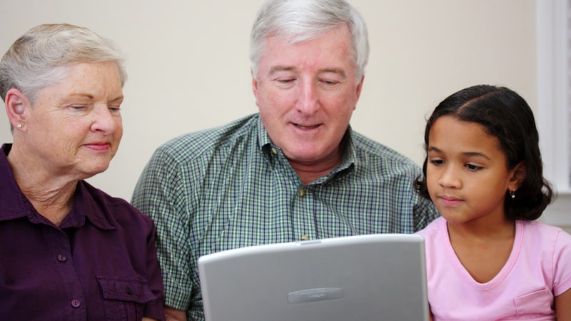 grandparents and granddaughter together looking at a laptop. Image by Rmarmion. For Jumble puzzles for kids and adults, with roosters and cave crafters